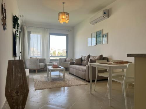 a living room with a couch and a table at 1BDR chalet on direct swimming pool Einbay in Ain Sokhna