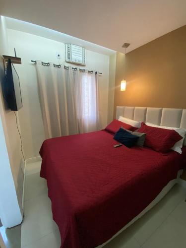 een slaapkamer met een rood bed en rode kussens bij Cop30 Apartmento in Belém
