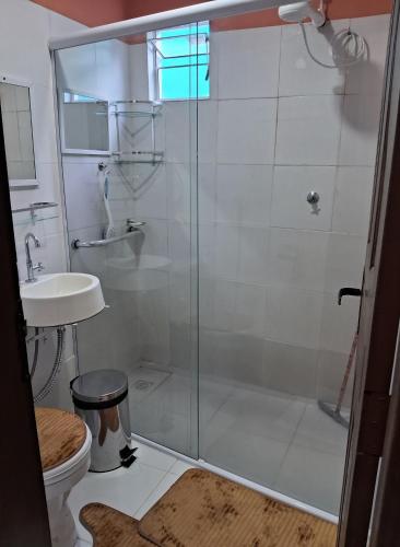 a bathroom with a shower with a toilet and a sink at Hospedagem Aconchego do Lar in Barreirinhas