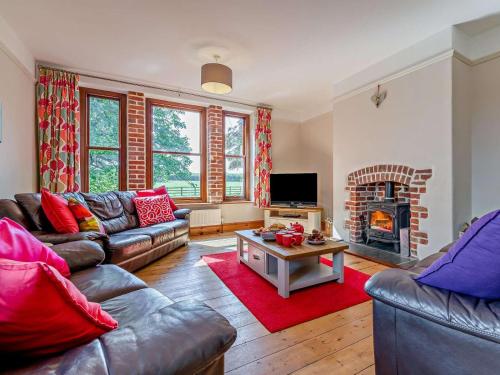 a living room with couches and a fire place at 4 Bed in Bude SSHAM in Stratton