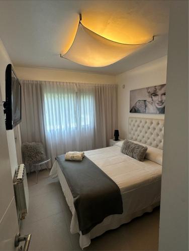 a bedroom with a large bed and a television at Arenas Calidas Carilo in Carilo