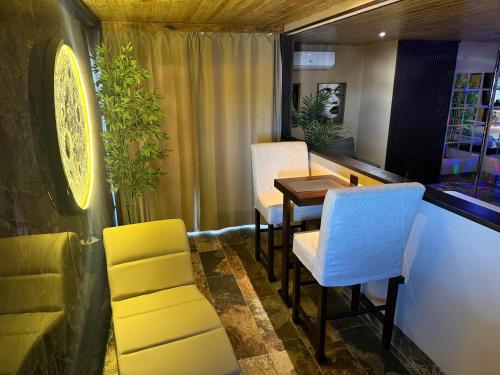 a dining room with yellow and white chairs and a table at Sosua Inn Hotel in Sosúa