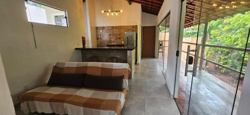 a room with two beds and a kitchen with glass doors at Sincorá Guesthouse in Lençóis