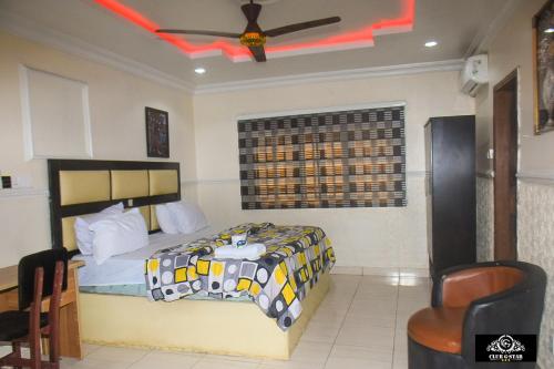 a bedroom with a bed and a ceiling fan at G-Star Hotel and Suites in Omole