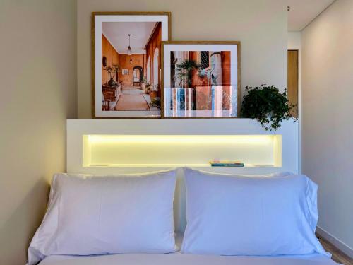 a bed with two pillows and a light above it at NextLiving Apartments by Wynwood House Chapinero in Bogotá