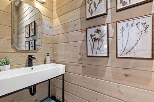 ein Badezimmer mit weißem Waschbecken und Holzwänden in der Unterkunft Ultra Luxury Cabin, Stunning Mtn Views, Game room in Mineral Bluff