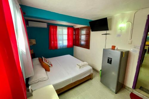 a small room with a small bed and a refrigerator at Isla Mujeres Punta Norte Private Bedroom 3 in Isla Mujeres