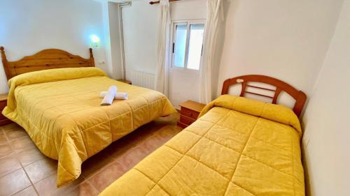 a bedroom with two beds with a white cross on it at Casa azul in Nerpio