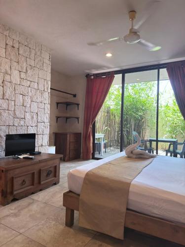 a bedroom with a king sized bed and a tv at Maya Vacanze Playa Natural in Playa del Carmen