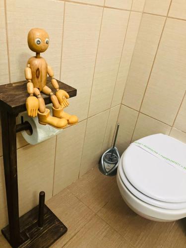 a wooden doll sitting on a shelf next to a toilet at Pensiunea Agroturistica Cerna, Vaideeni - Polovragi in Vaideeni