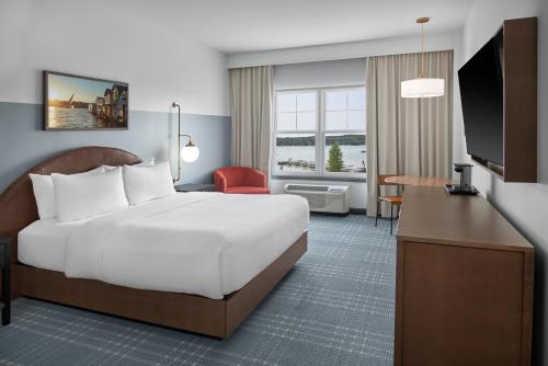 a hotel room with a large bed and a desk at Hotel Canandaigua, Tapestry Collection By Hilton in Canandaigua