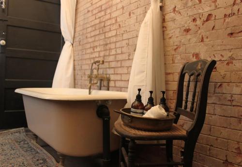 a bathroom with a tub and a sink and a chair at Downtown Casa Mina Cozy Free Parking in El Paso
