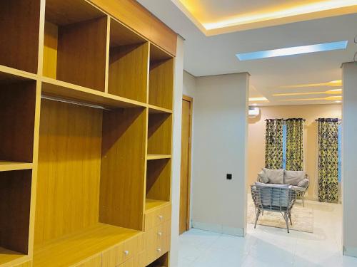 a living room with wooden shelves and a chair at GRACE LODGE LEKKI Phase 1 in Araromi