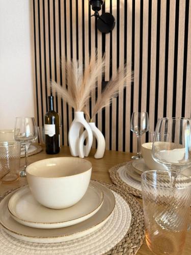 a table with plates and bowls and wine glasses at Holiday Leukerbad Mountain Nature Free Parking Free WiFi in Leukerbad