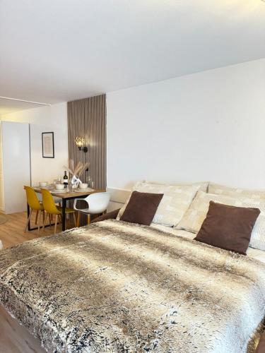 a bedroom with a large bed and a table at Holiday Leukerbad Mountain Nature Free Parking Free WiFi in Leukerbad