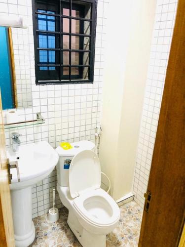 un bagno bianco con un water e un lavandino di IKN résidence a Douala
