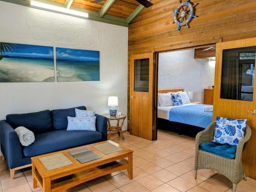 a living room with a couch and a bed at Beachside Cottage - A Private Peaceful Hidden Gem 50m to Beach in Nelly Bay