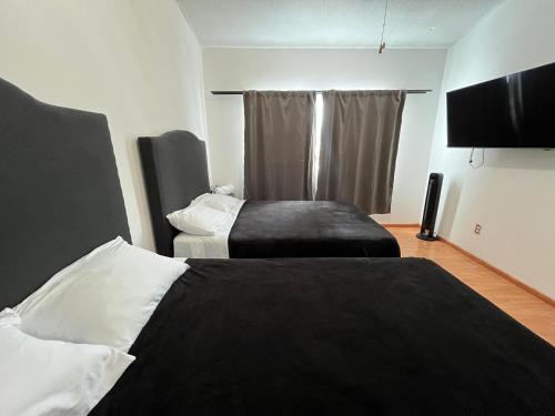 a bedroom with two beds and a flat screen tv at 23 Habitación doble cama in Miravalle