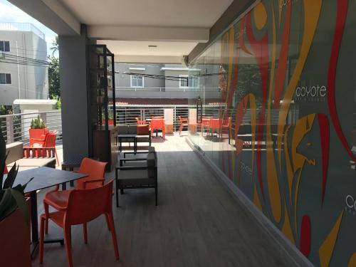 a restaurant with red chairs and tables and a mural at LA PERLA STUDIOS with ROOFTOP POOL and SPA - PLAYA LOS CORALES in Punta Cana