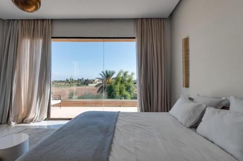 Un dormitorio con una cama grande y una ventana grande en Villa La Baraca, en Marrakech