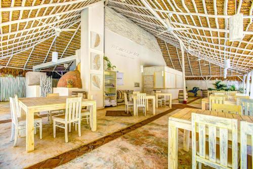 a dining room with tables and chairs and ceilings at LA PERLA STUDIOS with ROOFTOP POOL and SPA - PLAYA LOS CORALES in Punta Cana