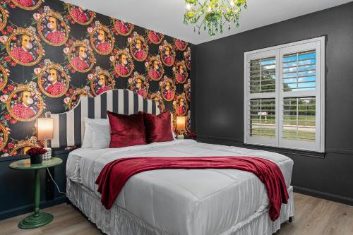 a bedroom with a large bed with red pillows at Bubble Bungalow - Cowboy Pool Hot Tub & Firepit in Fredericksburg