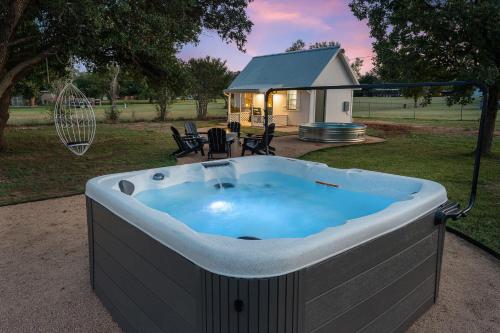 a large hot tub in a yard with a house at Bubble Bungalow - Cowboy Pool Hot Tub & Firepit in Fredericksburg