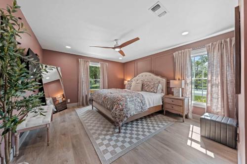 Un dormitorio con una cama y un ventilador de techo. en The Smith Haus - Sleeps 12 Pool Game Room, en Fredericksburg