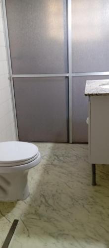 a bathroom with a white toilet and a shower at Casa Mobiliada próxima ao Batel in Curitiba