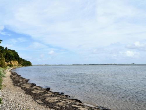 a large body of water with a rocky beach at Tranquil Nature Escape-By Traum in Thyholm