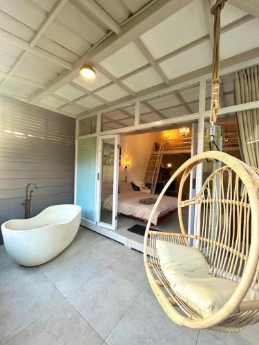 a room with a tub and a bed and a swing at Kawoeng kabin in Panjadakan
