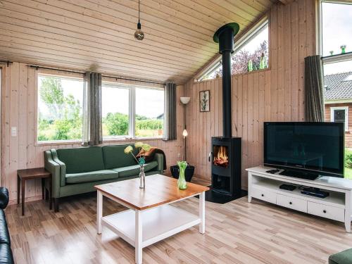 a living room with a couch and a tv and a fireplace at 10 person holiday home in Ansager in Ansager