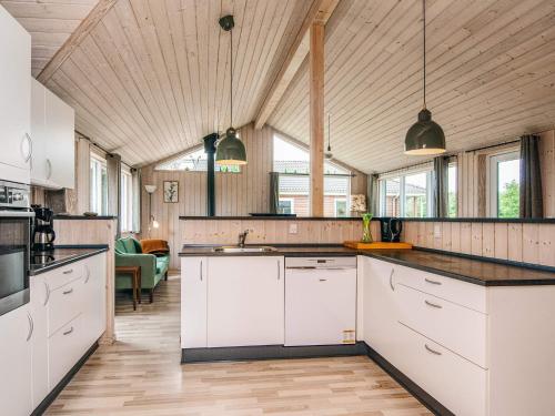 a large kitchen with white cabinets and windows at 10 person holiday home in Ansager in Ansager