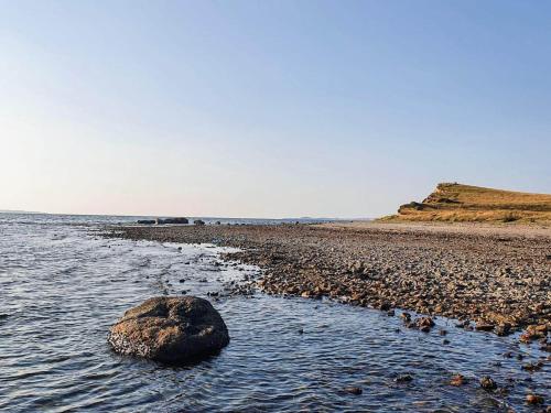 a rock in the water on a beach at 6 person holiday home in Løgstør-By Traum in Løgsted