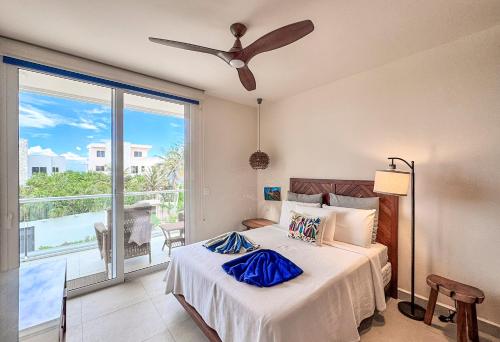 a bedroom with a bed with a ceiling fan at Tortuga Azul Private Terrace Rooftop Pool W BBQ Beach Access 11 Pools Free Beach Club in Akumal