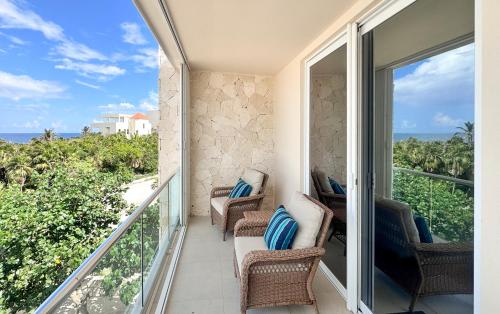 a balcony with chairs and a view of the ocean at Tortuga Azul Private Terrace Rooftop Pool W BBQ Beach Access 11 Pools Free Beach Club in Akumal