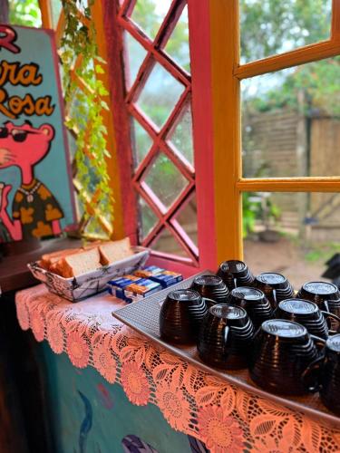 a table topped with black cupcakes on top of a window at Hostel Pantera do Rosa in Praia do Rosa