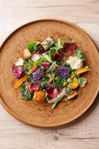 a plate of vegetables on a wooden table at SHISHI-IWA HOUSE Karuizawa in Karuizawa
