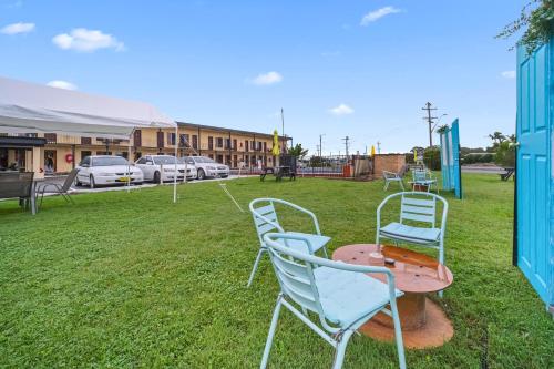 a group of chairs sitting on the grass at Country Plaza Motel Taree in Taree