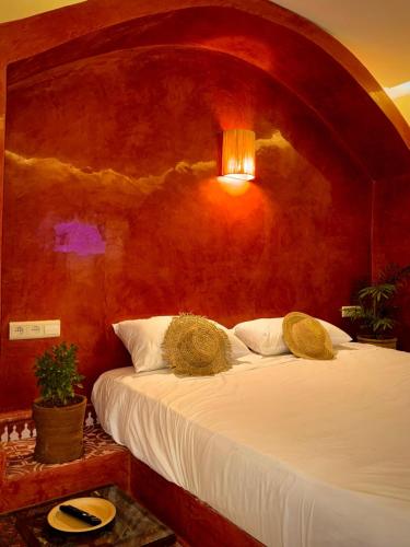 a bedroom with a large bed with a red wall at Domaine JJ in Marrakech