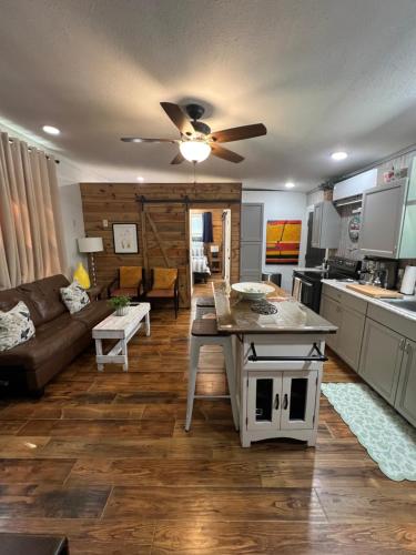 a kitchen and living room with a ceiling fan at Barn Door Themed Garvan Gardens Blue Bungalow in Hot Springs