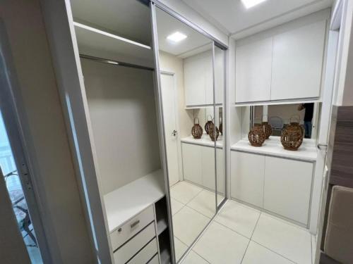 a bathroom with white cabinets and a walk in shower at Golf Ville Resorts Residence 3 Suítes, Porto das Dunas in Aquiraz