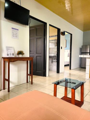 a living room with a table and a tv on the wall at Butterfly Apartments in Fortuna