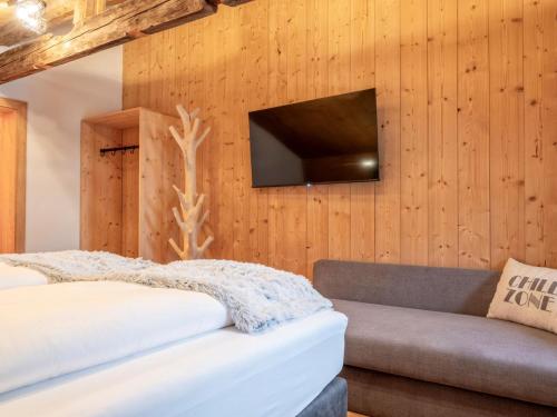 a bedroom with a bed and a tv on a wall at Hausa Sommer in Grossarl