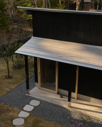 a building with a wooden roof and a window at SHISHI-IWA HOUSE Karuizawa in Karuizawa