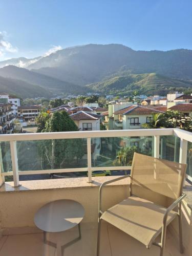 a balcony with a chair and a view of a city at Apart 329 Porto Marina Mont Blanc Refúgio aconchegante com vista privilegiada para a serra, dentro do Hotel in Mangaratiba