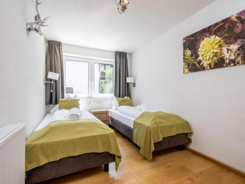 a bedroom with two beds and a window at Cervus in Bruck an der Großglocknerstraße