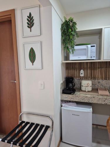 a kitchen with a refrigerator and a microwave at Apart 329 Porto Marina Mont Blanc Refúgio aconchegante com vista privilegiada para a serra, dentro do Hotel in Mangaratiba