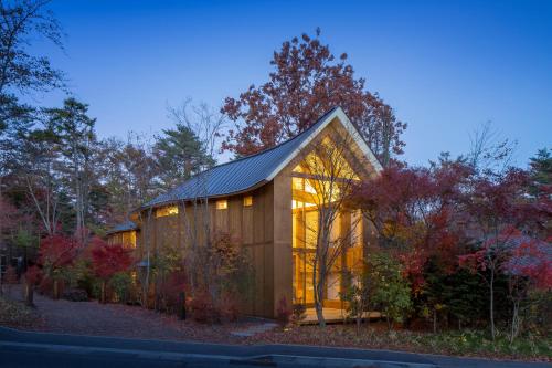 a small wooden house with a metal roof at SHISHI-IWA HOUSE Karuizawa in Karuizawa