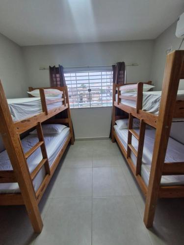 two bunk beds in a room with a window at Açaí Hostel in Belém